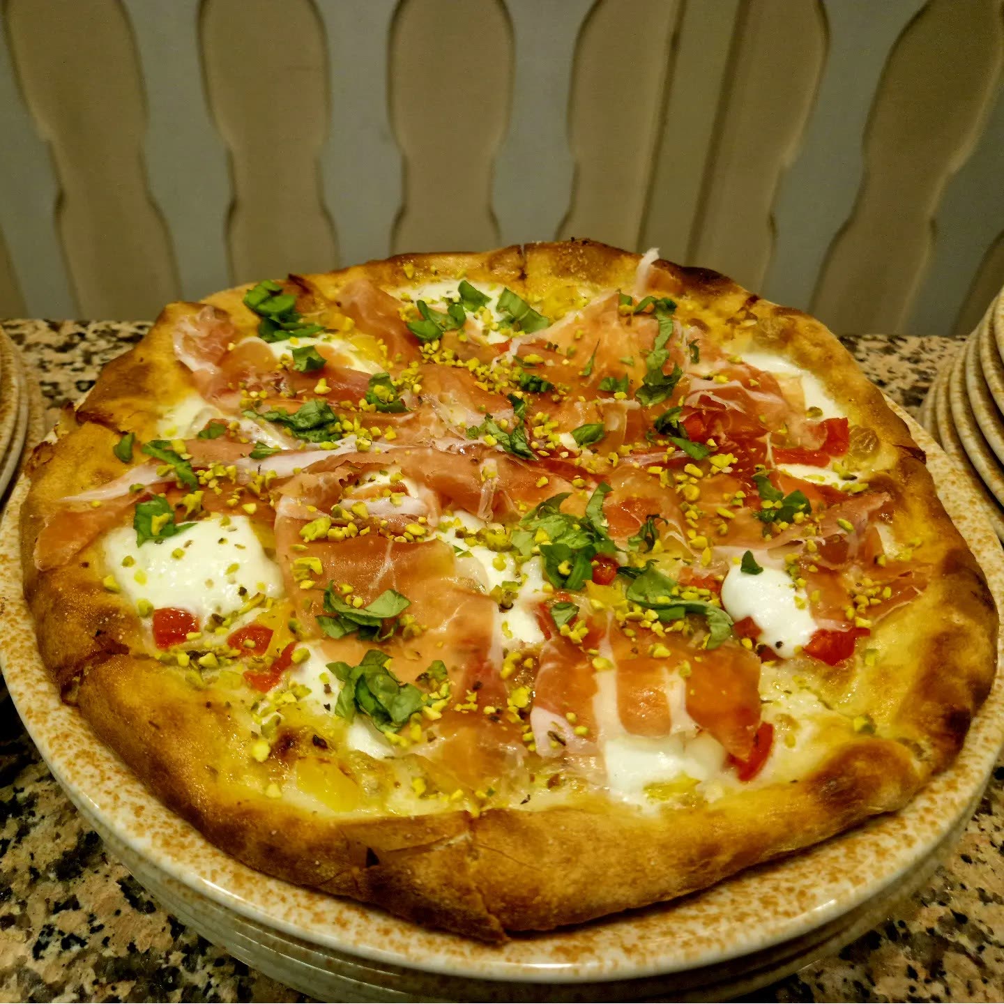 Pizza con prosciutto e pistacchio